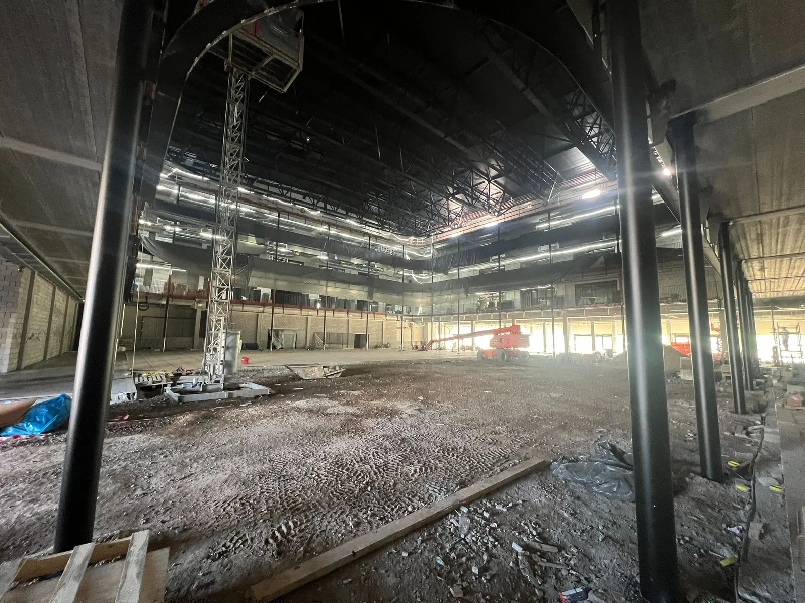 Large commercial building interior under construction with ventilation ductwork and steel structure