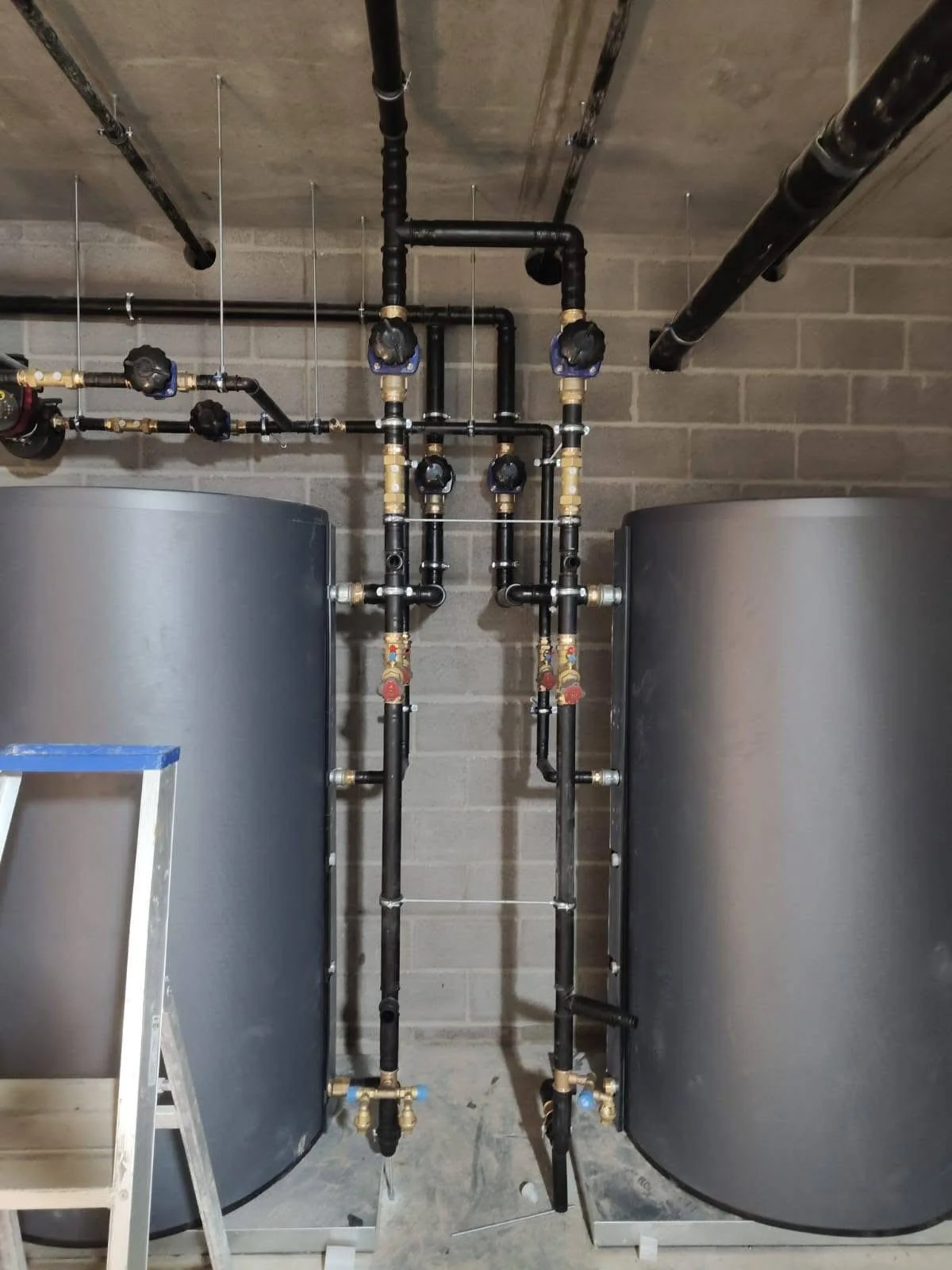 Completed industrial plant interior showing installed HVAC systems and overhead pipework